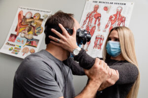 Dix-hallpike test for BPPV. A Physiotherapist holds a clients head to the side while they wear VNG goggles so she can treat his vertigo caused by BPPV.